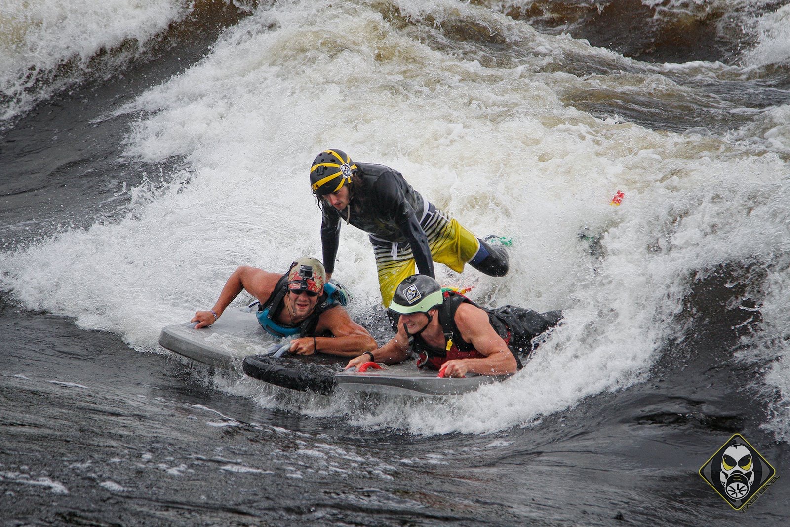 Three riverboarders riding a wave train together