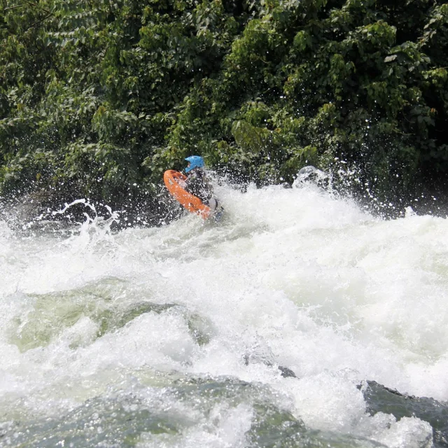 Asaf Arad charging a whitewater rapid on an orange riverboard