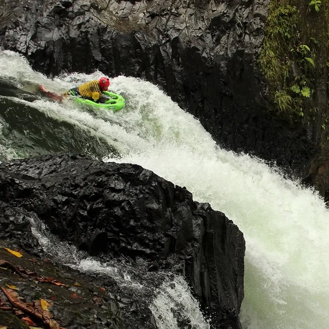 Josh Galt running a steep waterfall on a green riverboard